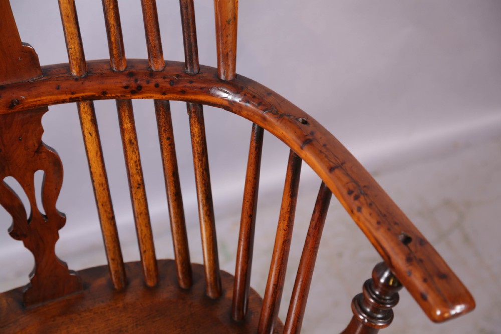 An antique yew wood high back Windsor armchair featuring a pierced central splat, spindled hoop back, turned legs, and a solid shaped seat. View VII