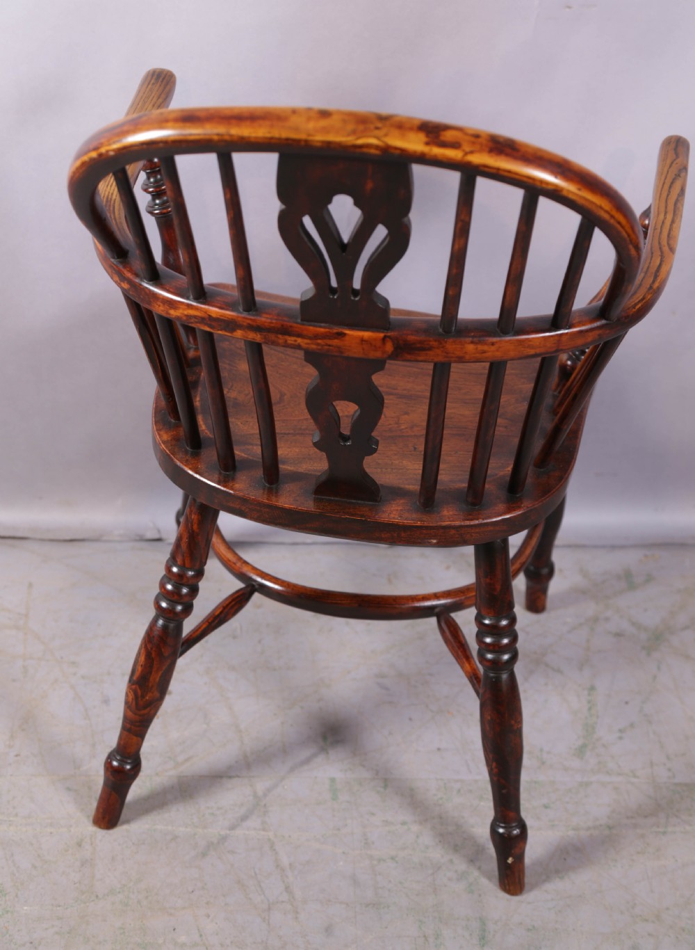 An antique ash and elm Windsor armchair featuring a steam-bent hoop back, pierced splat, turned legs, and a crinoline stretcher. View III