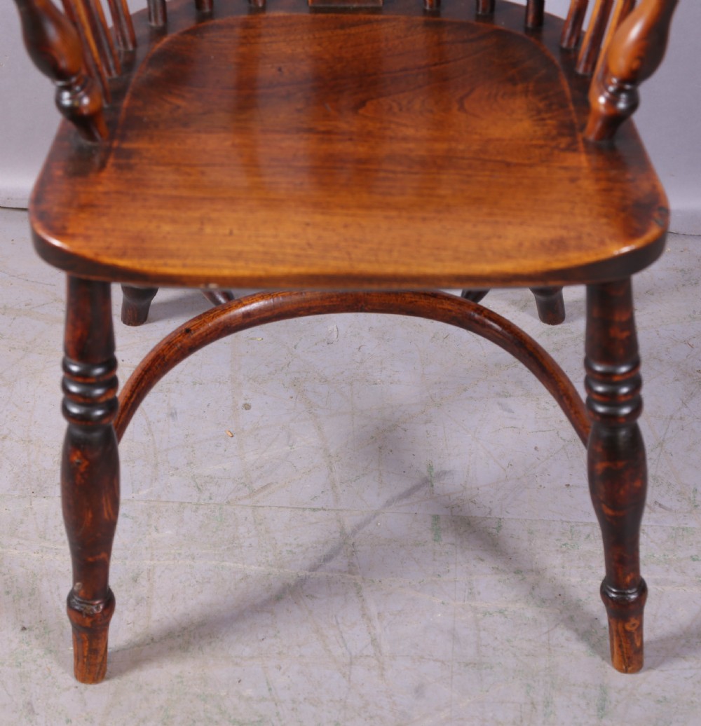 An antique ash and elm Windsor armchair featuring a steam-bent hoop back, pierced splat, turned legs, and a crinoline stretcher. View IV
