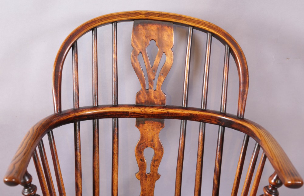 An antique ash and elm Windsor armchair featuring a steam-bent hoop back, pierced splat, turned legs, and a crinoline stretcher. View VI