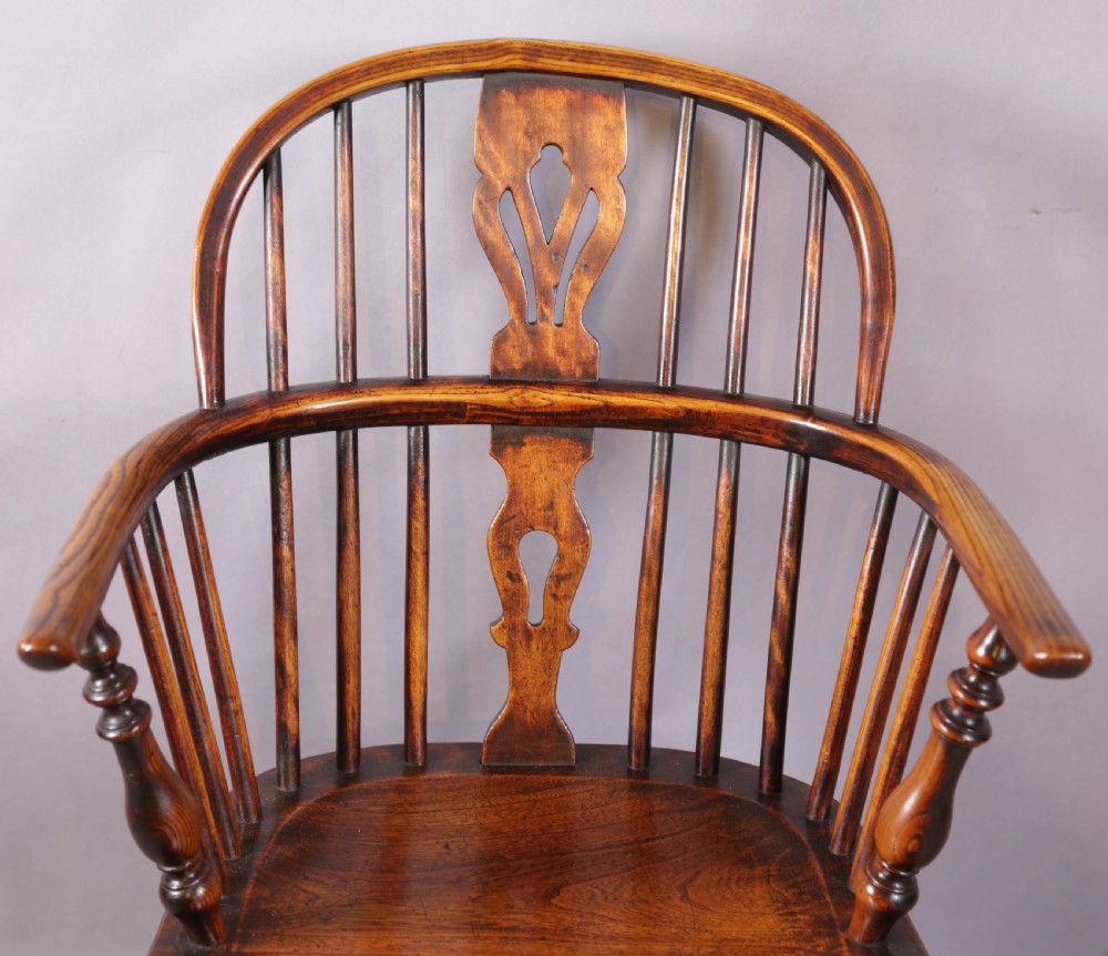 An antique ash and elm Windsor armchair featuring a steam-bent hoop back, pierced splat, turned legs, and a crinoline stretcher. View VII