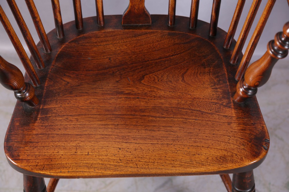 An antique ash and elm Windsor armchair featuring a steam-bent hoop back, pierced splat, turned legs, and a crinoline stretcher. View VIII
