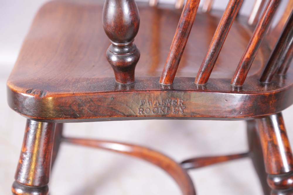 An antique ash and elm Windsor armchair featuring a steam-bent hoop back, pierced splat, turned legs, and a crinoline stretcher. View X