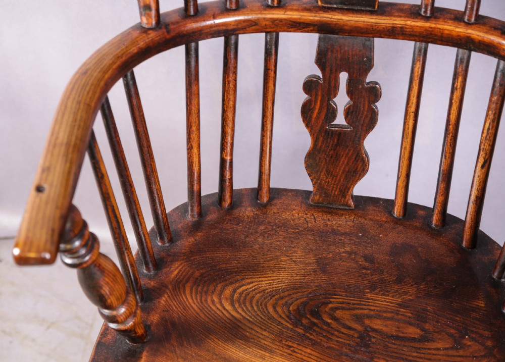 An antique high-back wooden Windsor armchair crafted from ash and elm with a pierced central splat, turned legs, and a shaped saddle seat. View VIII