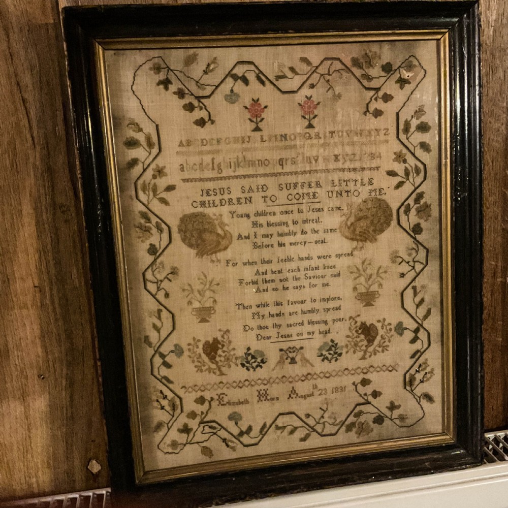 Framed 1831 needlework sampler featuring an embroidered alphabet, religious verse, peacocks, floral borders, and a signature dated August 23 1831. View VIII