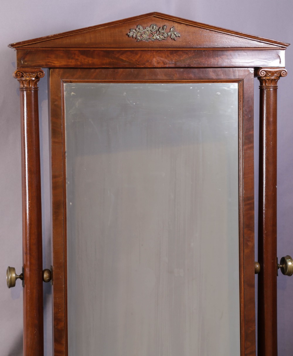 An American Empire mahogany cheval mirror with turned side columns, a pedimented top, brass mounts, and a carved scroll base with paw feet. View III