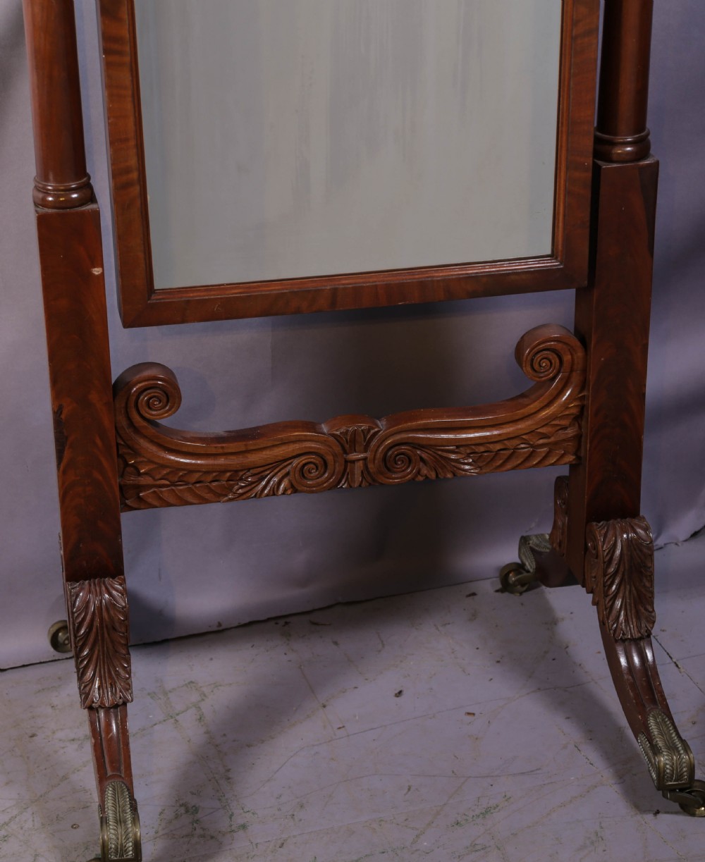 An American Empire mahogany cheval mirror with turned side columns, a pedimented top, brass mounts, and a carved scroll base with paw feet. View IV