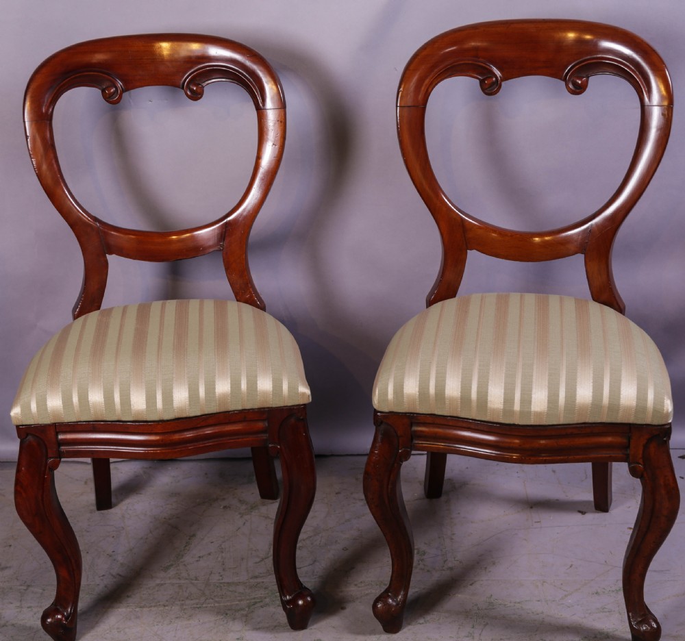 A set of ten Victorian mahogany dining chairs featuring characteristic balloon backrests and striped upholstery on cabriole legs. View VI
