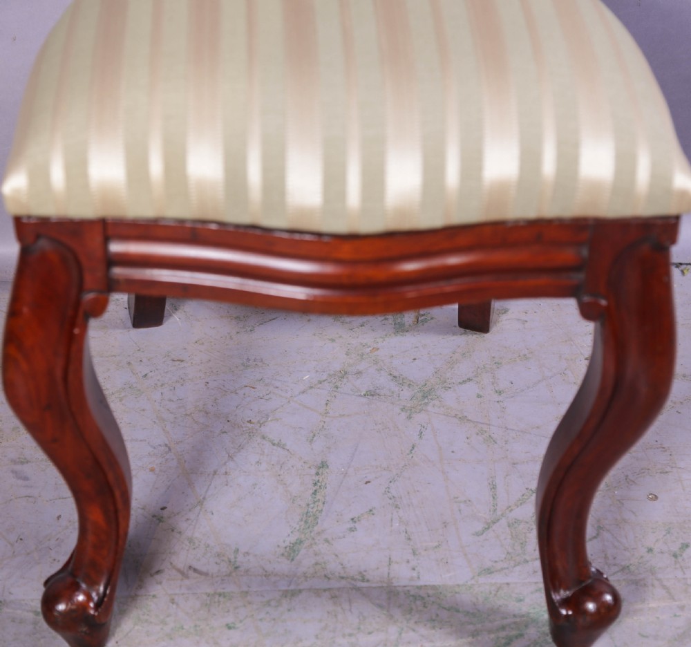 A set of ten Victorian mahogany dining chairs featuring characteristic balloon backrests and striped upholstery on cabriole legs. View IX