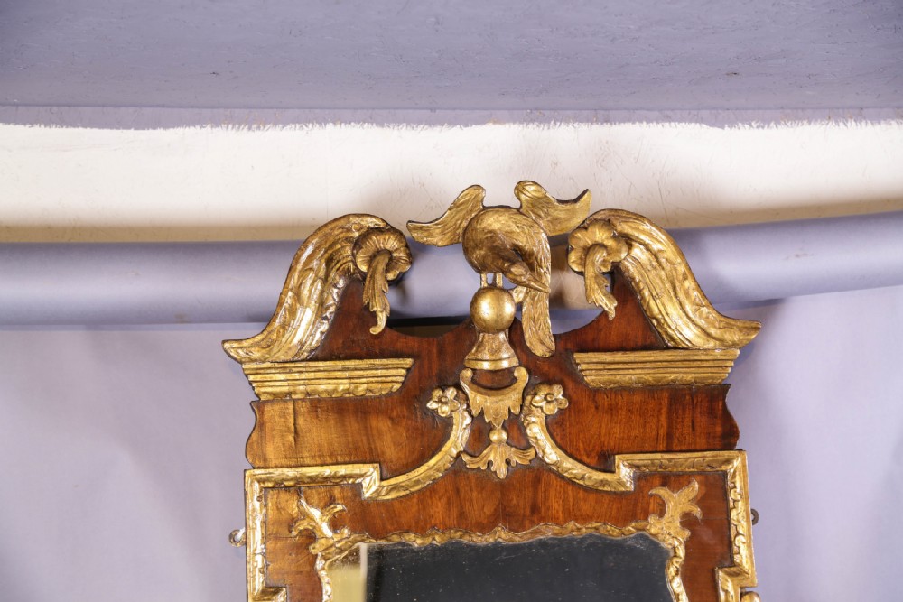 An 18th-century pier glass featuring a walnut veneer frame with elaborate giltwood carvings, scroll pediment, and a central carved eagle cresting. View III