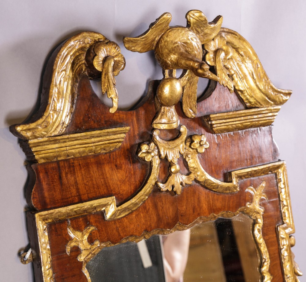 An 18th-century pier glass featuring a walnut veneer frame with elaborate giltwood carvings, scroll pediment, and a central carved eagle cresting. View X