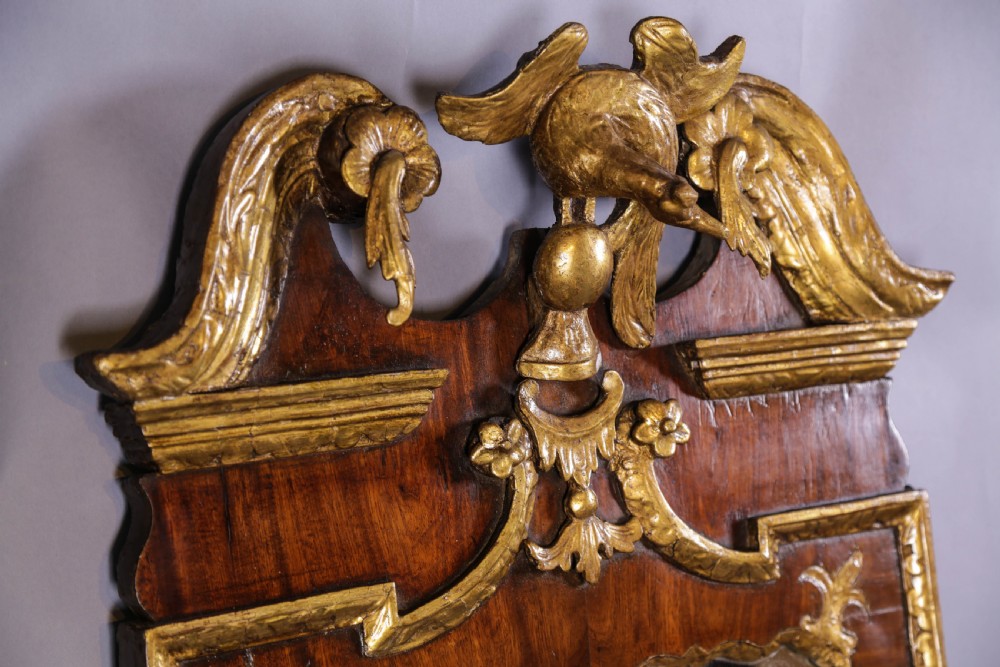 An 18th-century pier glass featuring a walnut veneer frame with elaborate giltwood carvings, scroll pediment, and a central carved eagle cresting. View XI