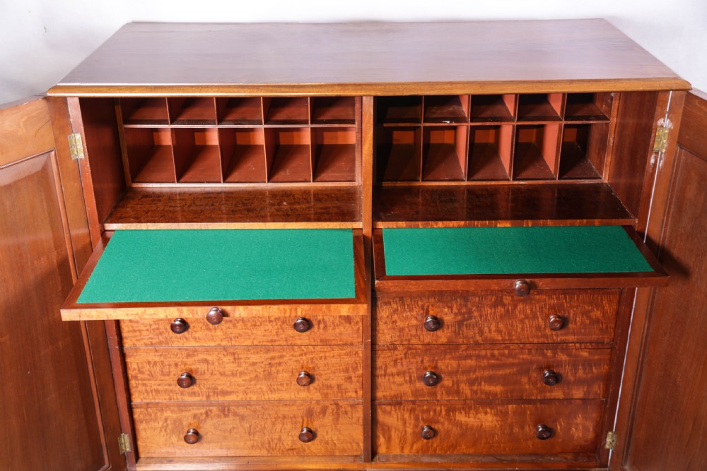 A 19th-century flame mahogany two-door estate cabinet with carved spandrel mouldings and turned bun feet. View VIII