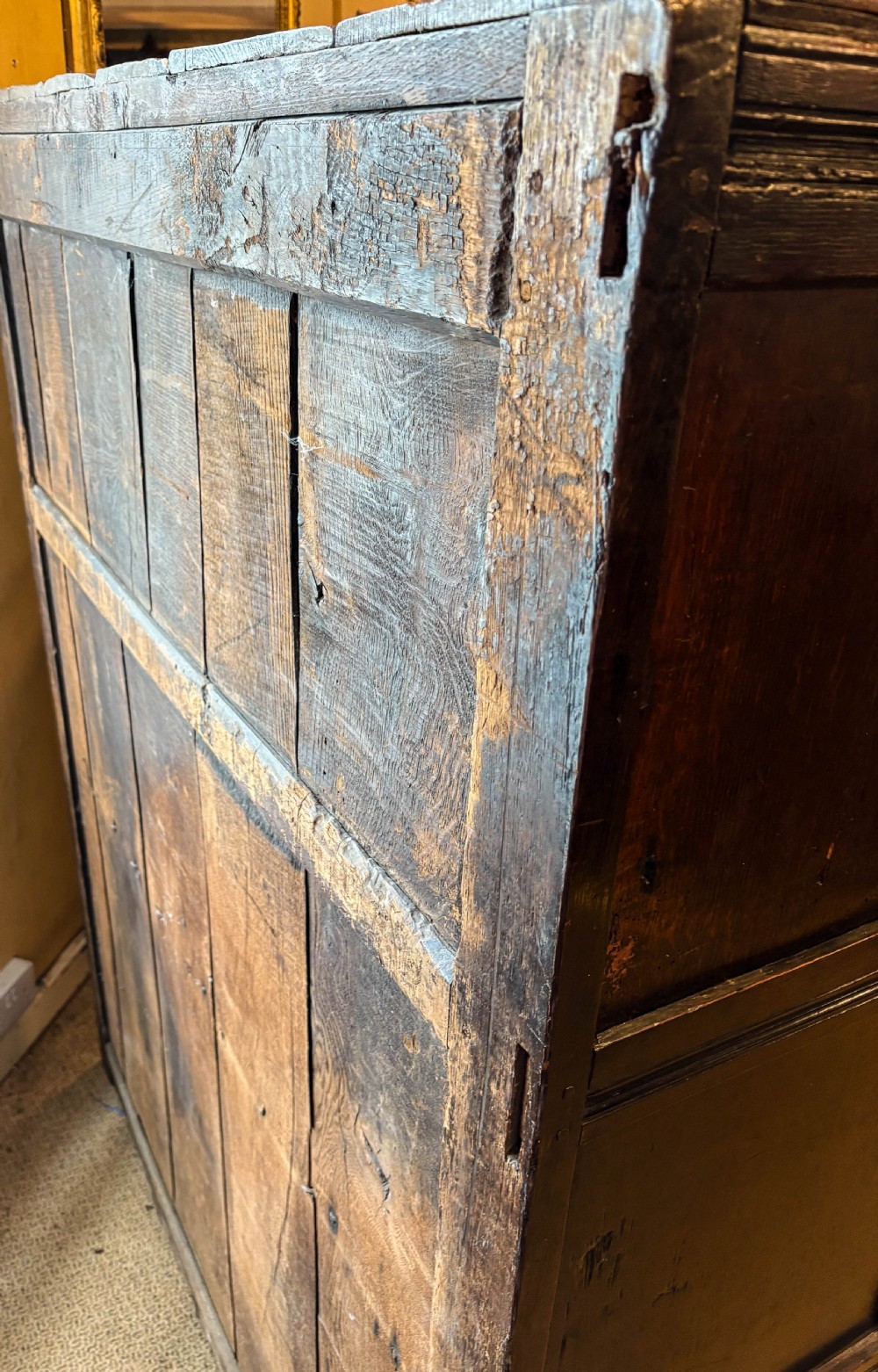 A front view of a dark brown antique oak livery cupboard featuring elaborate hand-carved geometric panels, friezes, and cupboard doors. View XIV
