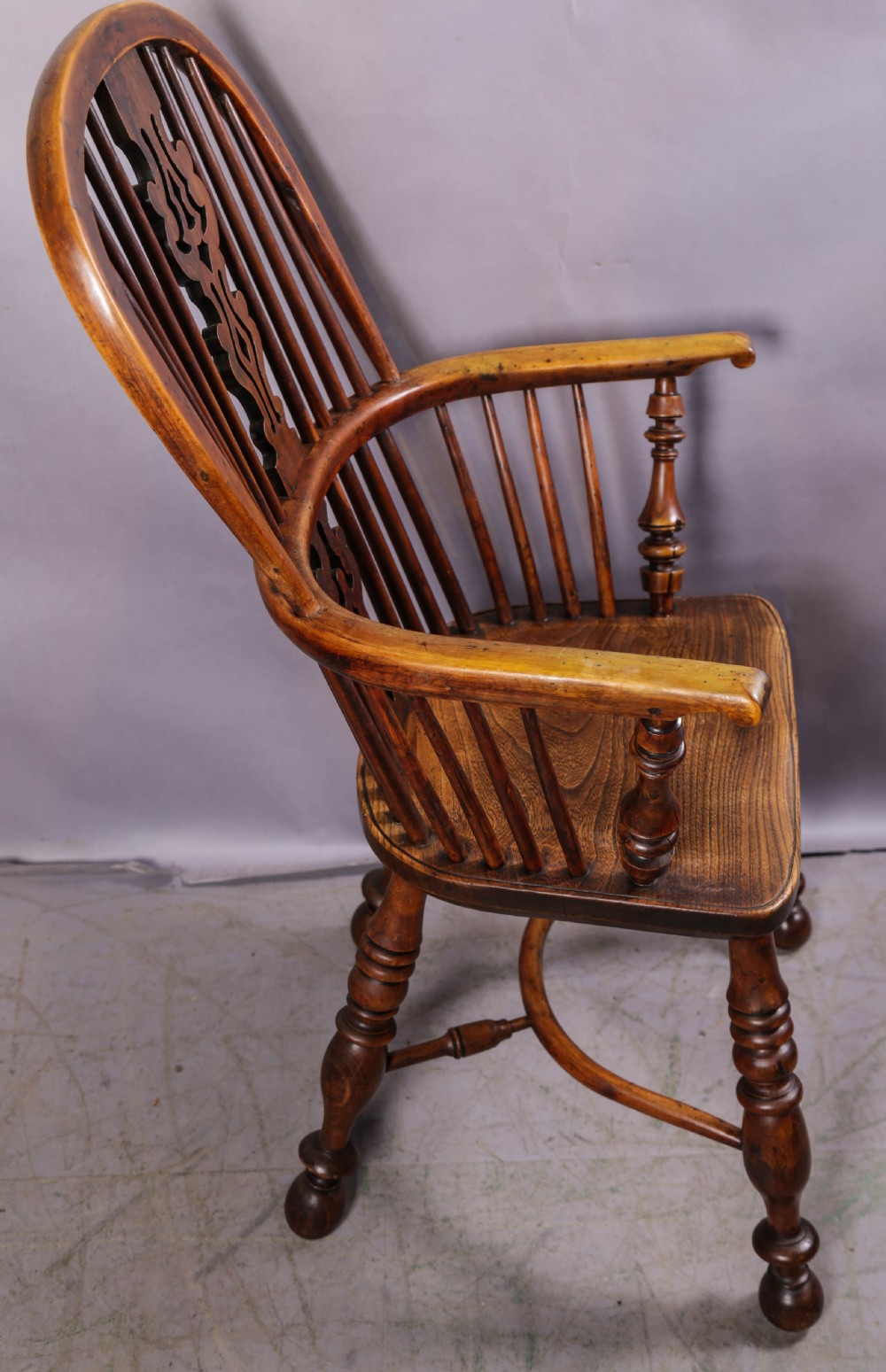 A 19th-century yew wood Windsor armchair featuring a bow back, ornate pierced splat, turned spindles, shaped seat, and turned legs. View II
