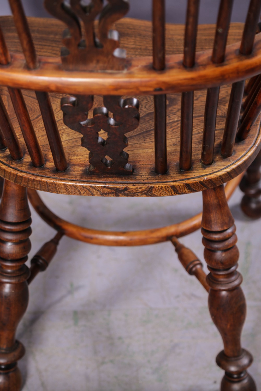 A 19th-century yew wood Windsor armchair featuring a bow back, ornate pierced splat, turned spindles, shaped seat, and turned legs. View IV