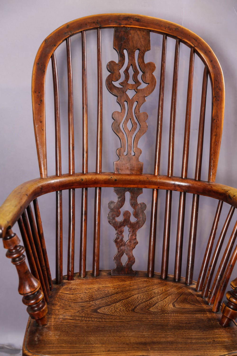 A 19th-century yew wood Windsor armchair featuring a bow back, ornate pierced splat, turned spindles, shaped seat, and turned legs. View VIII