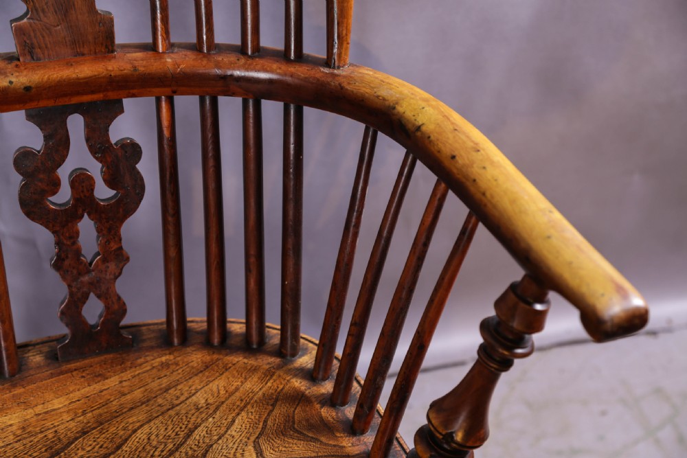 A 19th-century yew wood Windsor armchair featuring a bow back, ornate pierced splat, turned spindles, shaped seat, and turned legs. View X