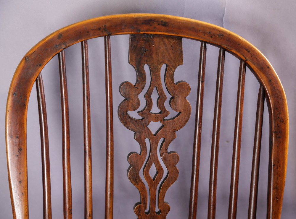 A 19th-century yew wood Windsor armchair featuring a bow back, ornate pierced splat, turned spindles, shaped seat, and turned legs. View XI