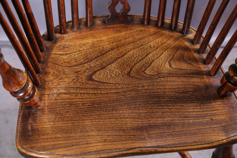 A 19th-century yew wood Windsor armchair featuring a bow back, ornate pierced splat, turned spindles, shaped seat, and turned legs. View XII