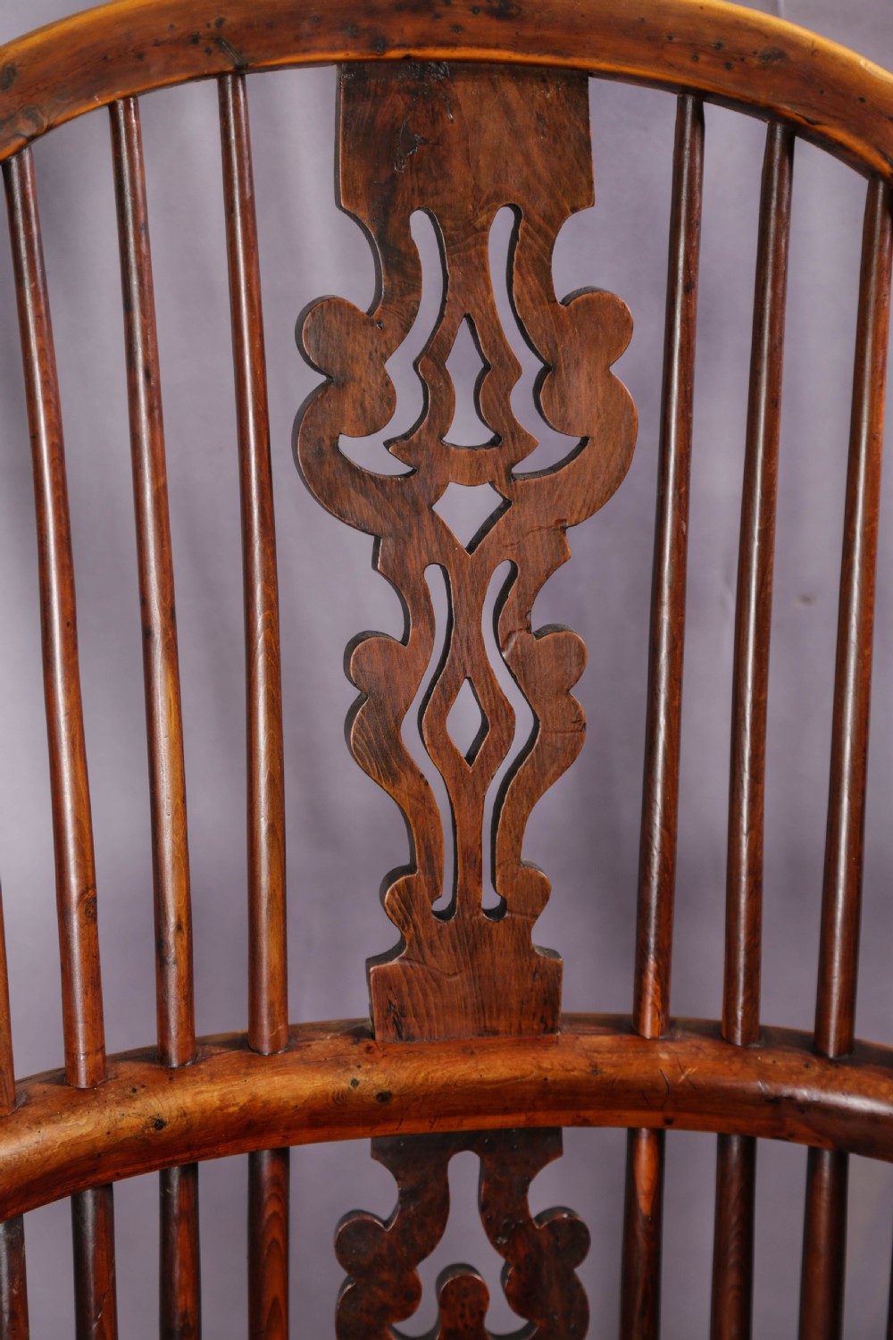 A 19th-century yew wood Windsor armchair featuring a bow back, ornate pierced splat, turned spindles, shaped seat, and turned legs. View XIII