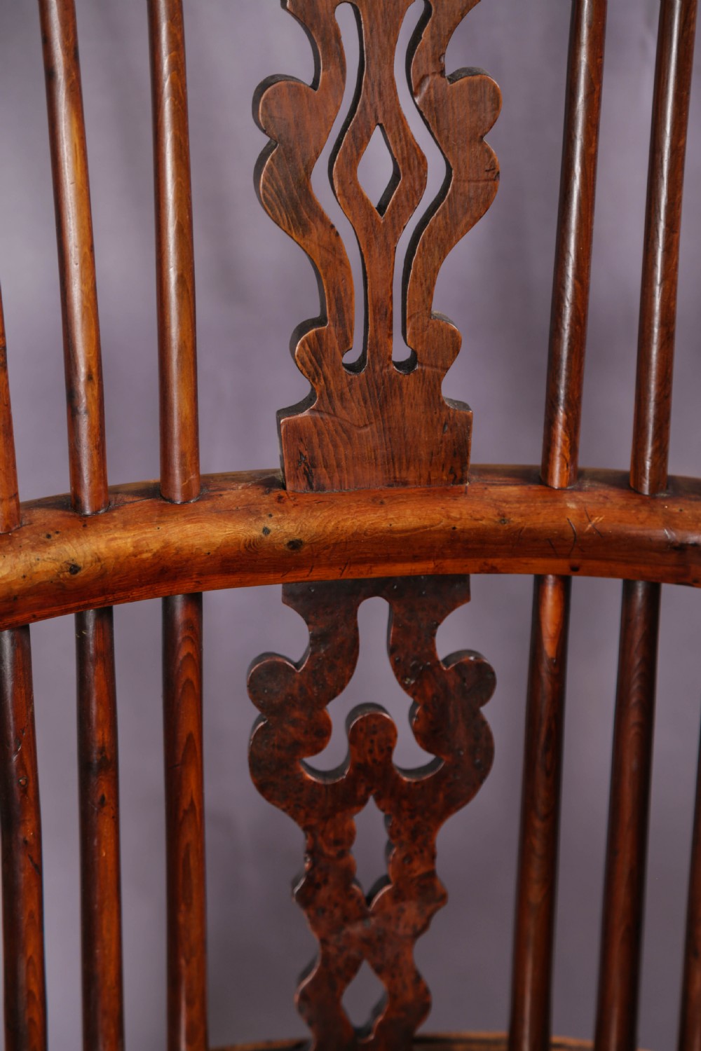 A 19th-century yew wood Windsor armchair featuring a bow back, ornate pierced splat, turned spindles, shaped seat, and turned legs. View XIV