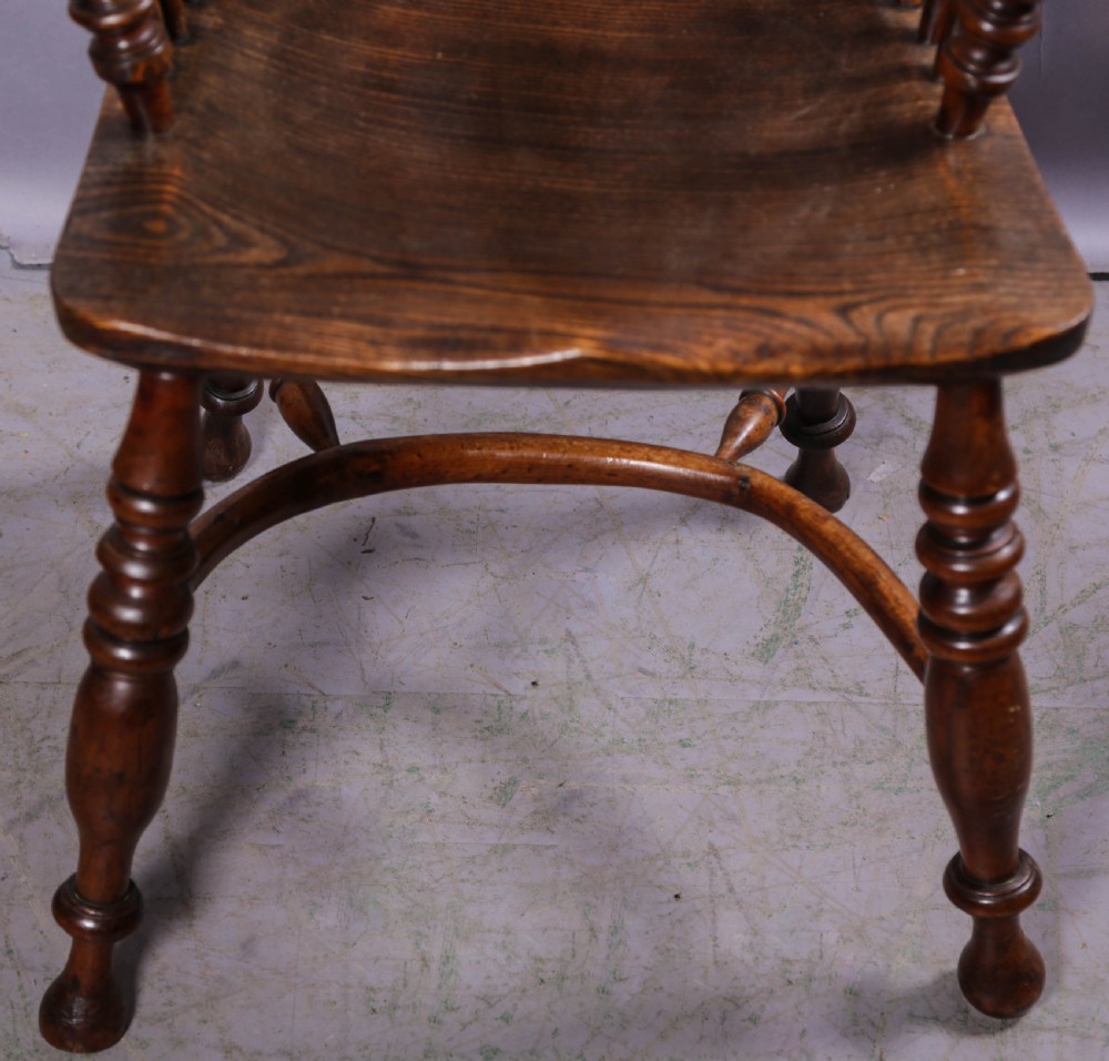 An antique yew wood high-back Windsor armchair featuring a pierced decorative splat, spindle back, shaped elm seat, turned legs, and a curved stretcher. View II