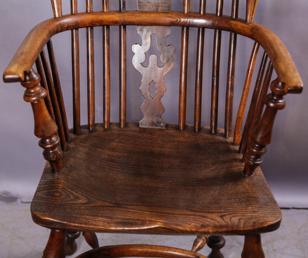 An antique yew wood high-back Windsor armchair featuring a pierced decorative splat, spindle back, shaped elm seat, turned legs, and a curved stretcher. View III