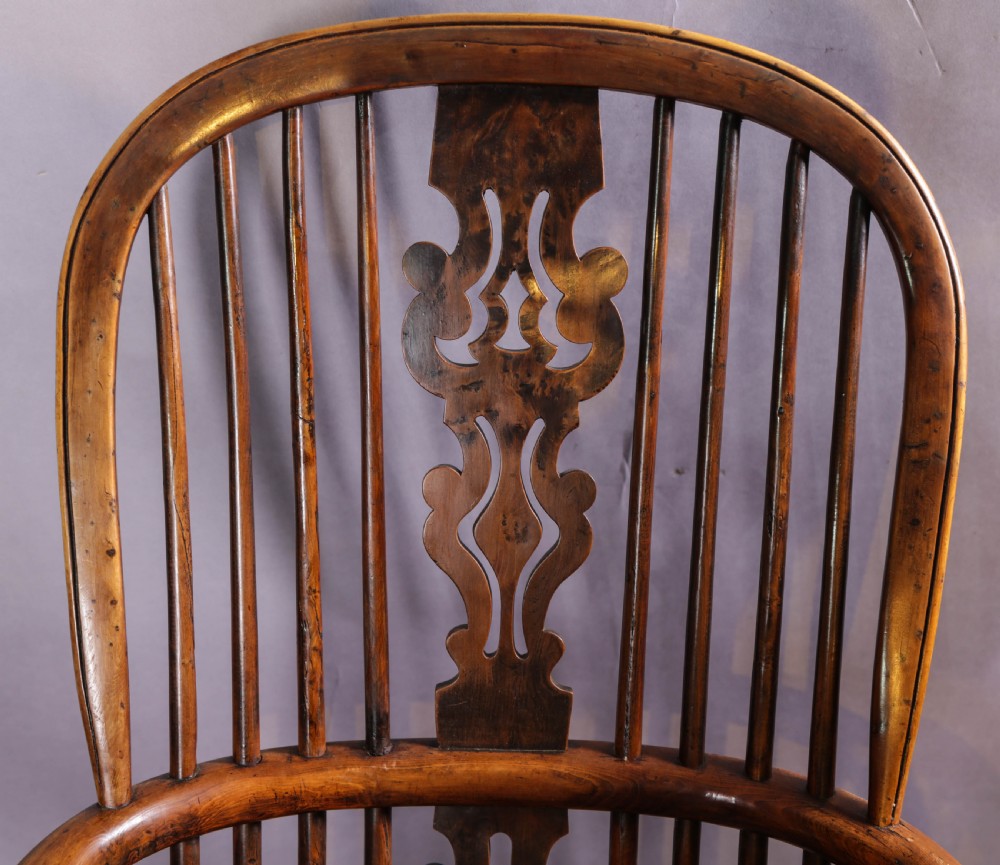 An antique yew wood high-back Windsor armchair featuring a pierced decorative splat, spindle back, shaped elm seat, turned legs, and a curved stretcher. View VII