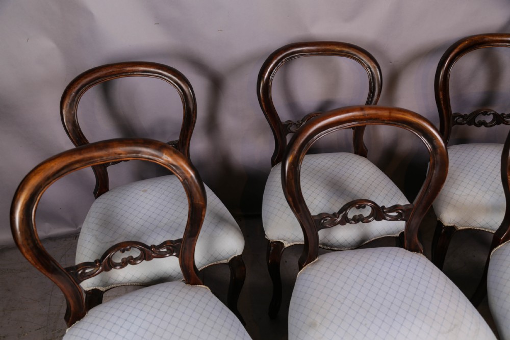 A set of six dark mahogany Victorian dining chairs featuring rounded balloon backrests with carved mid-rails and light-coloured patterned upholstered seats. View II