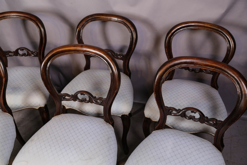 A set of six dark mahogany Victorian dining chairs featuring rounded balloon backrests with carved mid-rails and light-coloured patterned upholstered seats. View III