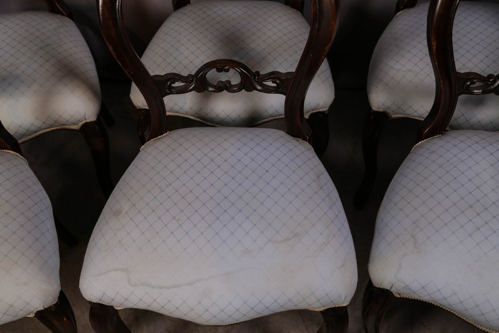 A set of six dark mahogany Victorian dining chairs featuring rounded balloon backrests with carved mid-rails and light-coloured patterned upholstered seats. View IV
