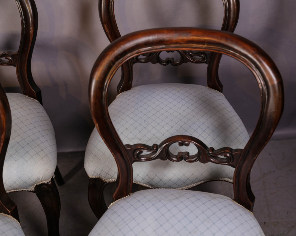 A set of six dark mahogany Victorian dining chairs featuring rounded balloon backrests with carved mid-rails and light-coloured patterned upholstered seats. View VIII