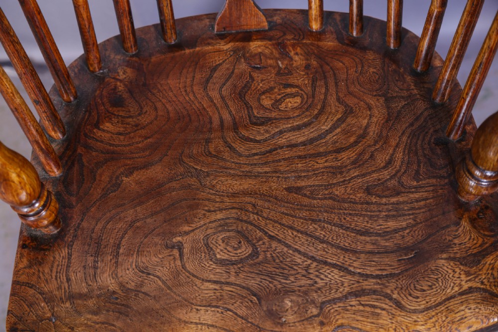 A low back ash and elm Windsor armchair featuring a shaped solid elm saddle seat, turned legs, curved stretcher, and a pierced splat back. View VI