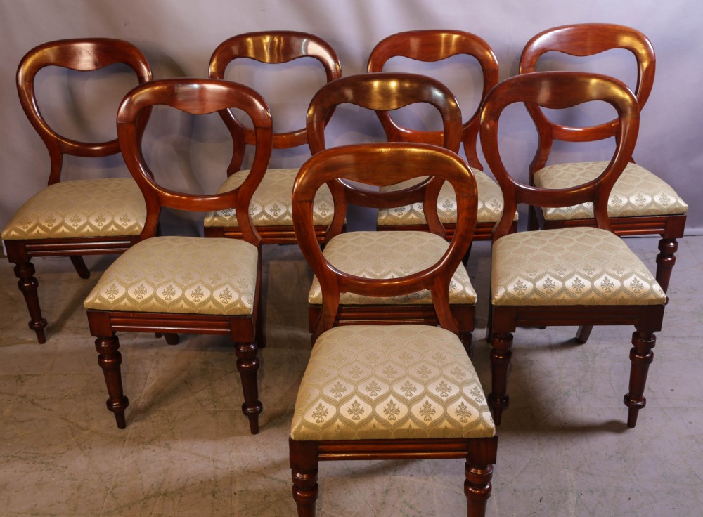Set of eight Victorian mahogany dining chairs featuring rounded balloon backs, turned front legs, and patterned light-coloured upholstered seats. View II