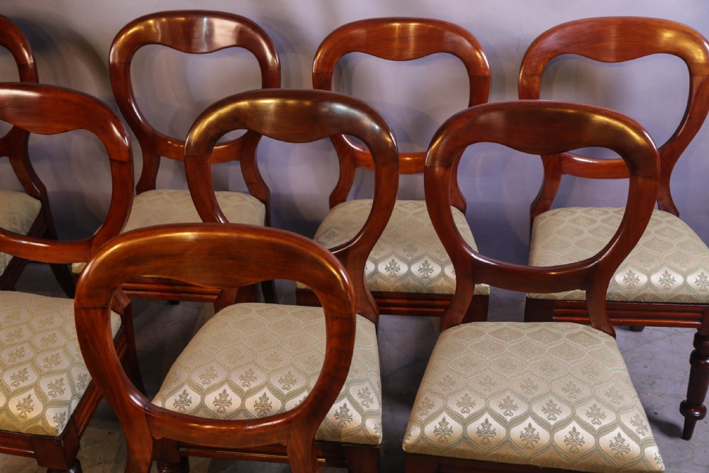 Set of eight Victorian mahogany dining chairs featuring rounded balloon backs, turned front legs, and patterned light-coloured upholstered seats. View III