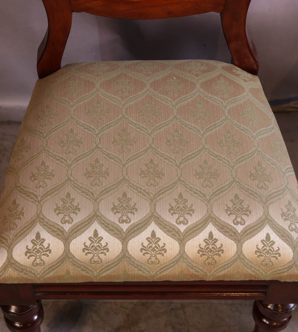 Set of eight Victorian mahogany dining chairs featuring rounded balloon backs, turned front legs, and patterned light-coloured upholstered seats. View VI