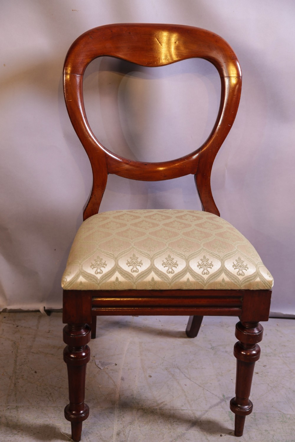 Set of eight Victorian mahogany dining chairs featuring rounded balloon backs, turned front legs, and patterned light-coloured upholstered seats. View VIII