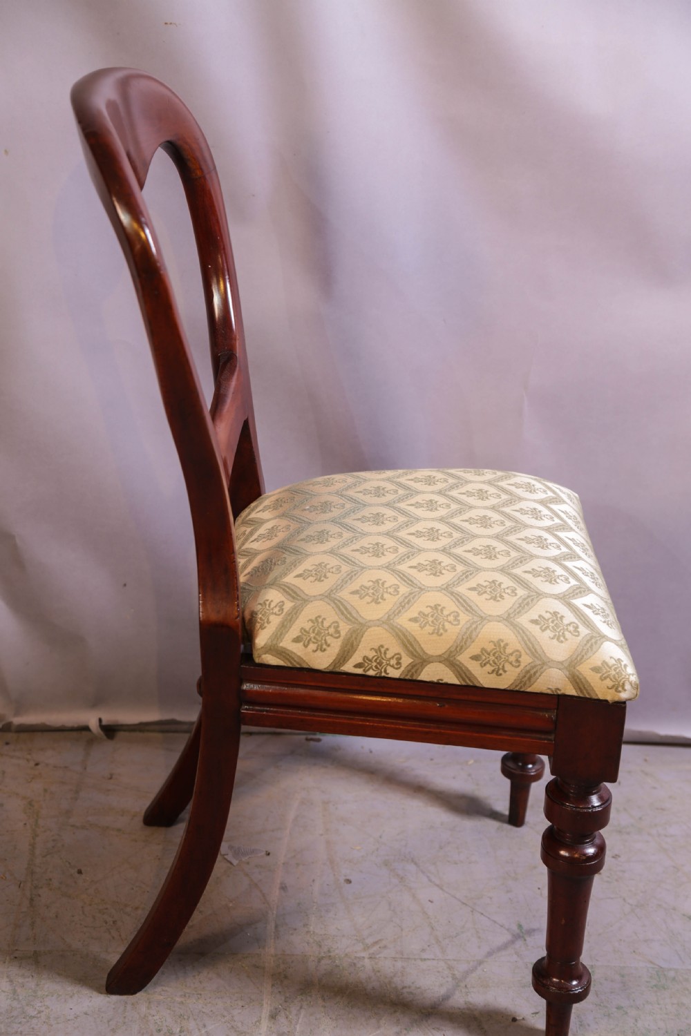 Set of eight Victorian mahogany dining chairs featuring rounded balloon backs, turned front legs, and patterned light-coloured upholstered seats. View IX
