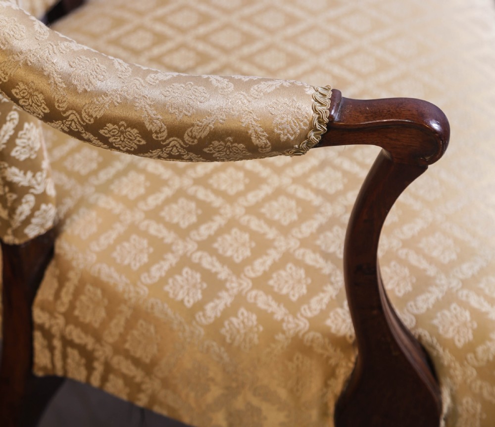 A pair of Georgian period mahogany armchairs upholstered in gold pattern damask fabric with swept timber arms. View VIII