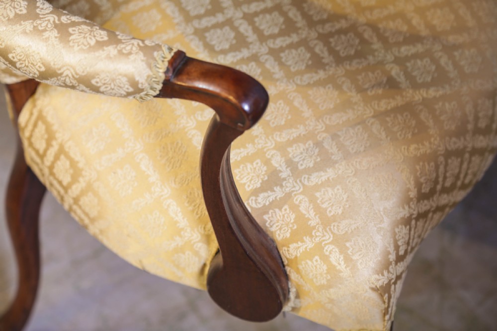 A pair of Georgian period mahogany armchairs upholstered in gold pattern damask fabric with swept timber arms. View XVI