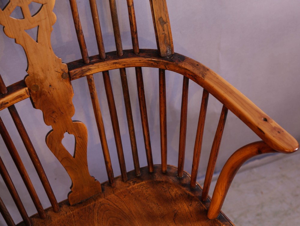 An antique Thames Valley yew wood Windsor armchair featuring a hoop back, central pierced wheel splat, contoured saddle seat, and turned legs. View VIII
