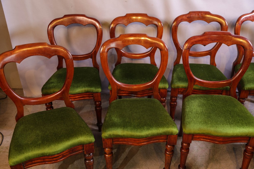 A set of eight Victorian mahogany balloon-back dining chairs with green velvet upholstered seats and turned front legs. View II