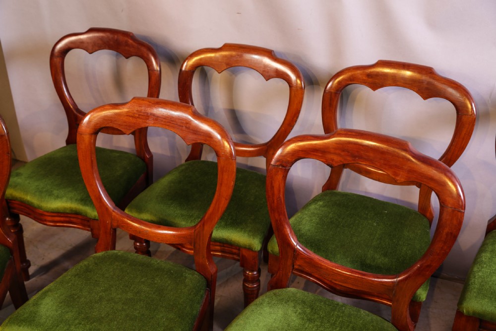 A set of eight Victorian mahogany balloon-back dining chairs with green velvet upholstered seats and turned front legs. View VI
