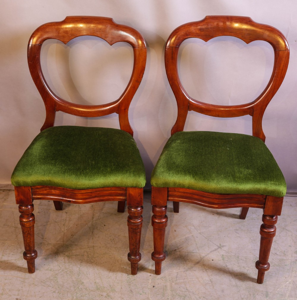 A set of eight Victorian mahogany balloon-back dining chairs with green velvet upholstered seats and turned front legs. View VII