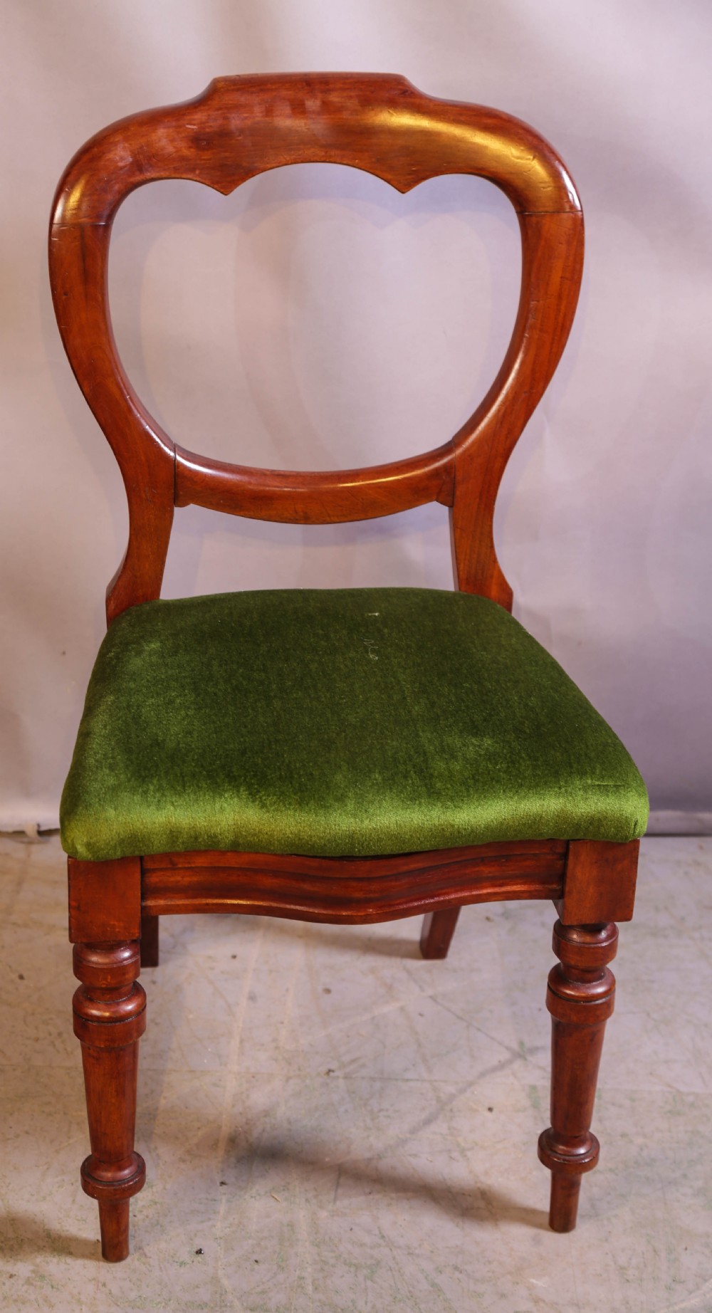A set of eight Victorian mahogany balloon-back dining chairs with green velvet upholstered seats and turned front legs. View VIII