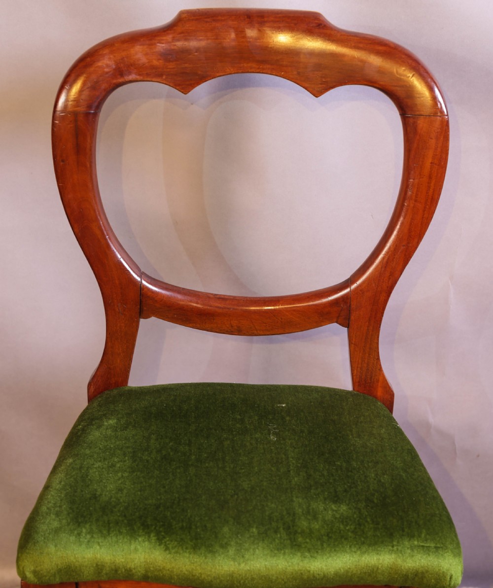 A set of eight Victorian mahogany balloon-back dining chairs with green velvet upholstered seats and turned front legs. View X