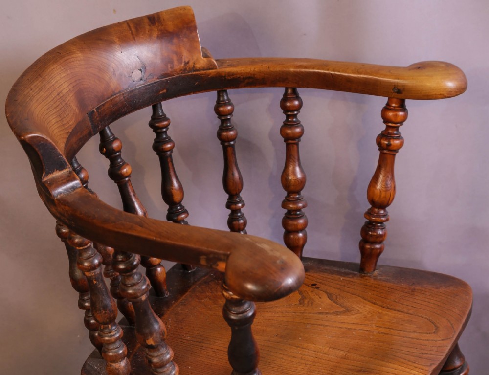 A Victorian captains chair made of polished yew wood featuring a curved crest rail, turned spindles, turned legs, and a solid shaped elm seat. View III