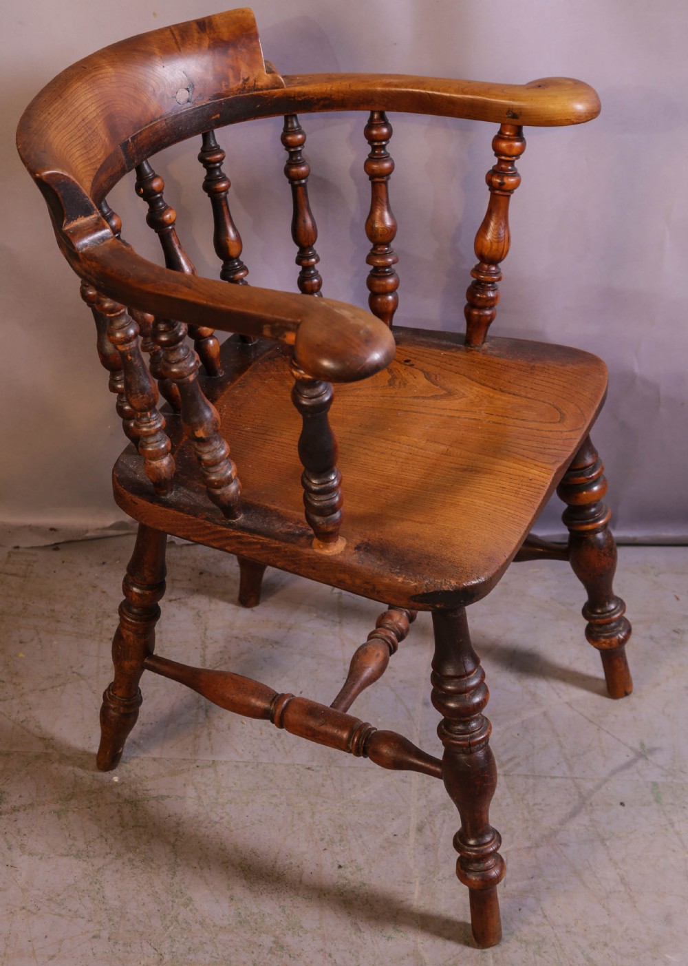 A Victorian captains chair made of polished yew wood featuring a curved crest rail, turned spindles, turned legs, and a solid shaped elm seat. View IV