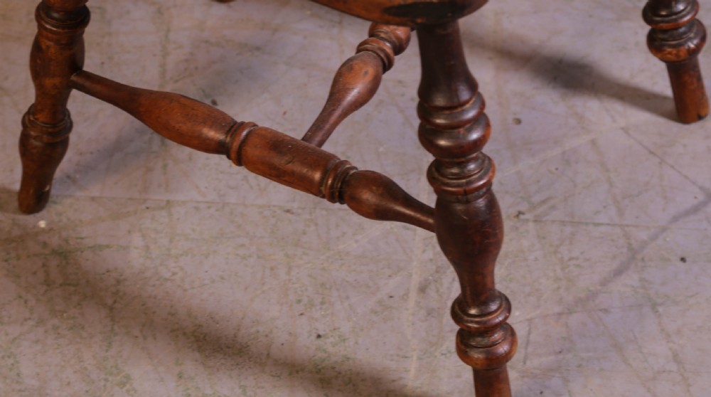 A Victorian captains chair made of polished yew wood featuring a curved crest rail, turned spindles, turned legs, and a solid shaped elm seat. View VI